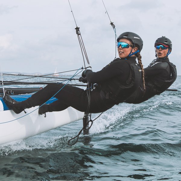 two people in code zero wetsuits sailing, click for code zero